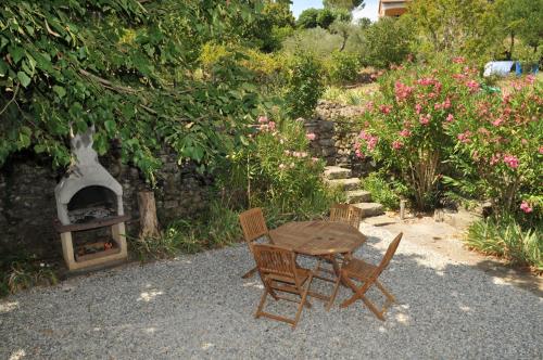 d'une table, de deux chaises et d'une cuisinière dans le jardin. dans l'établissement Mas d'Entraygues, à Gravières