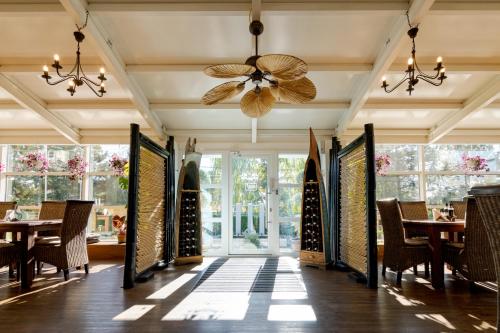 a dining room with tables and chairs and a ceiling fan at Casa Augsburg in Băneşti
