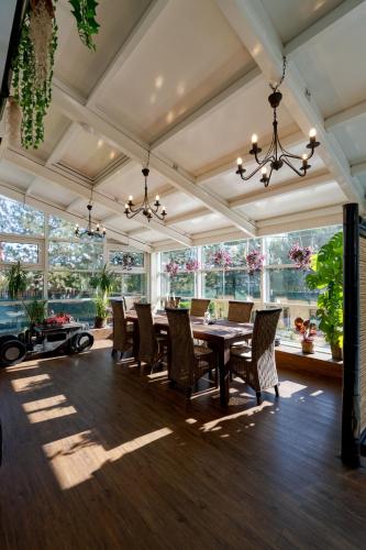 a dining room with a table and chairs and windows at Casa Augsburg in Băneşti