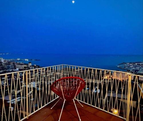 un fauteuil rouge installé au-dessus du balcon dans l'établissement Ti racconto il mare, à Salerne