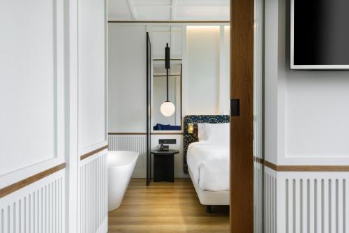 a bathroom with a bed and a bath tub and a television at Hotel Tres Reyes San Sebastián in Donostia-San Sebastián