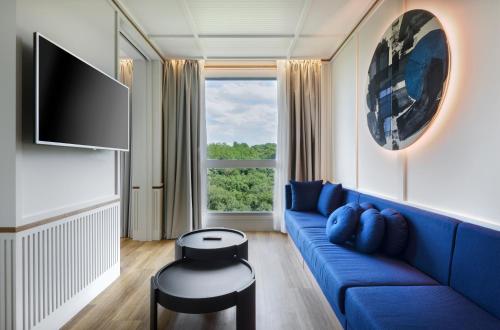 un soggiorno con divano blu e finestra di Hotel Tres Reyes San Sebastián a San Sebastián