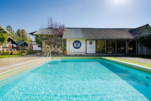 a swimming pool in front of a house at Casa Augsburg in Băneşti