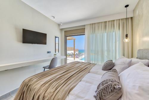 una camera con un grande letto e una televisione di Sabbia D`oro Beach Villa a Méson Yerakaríon