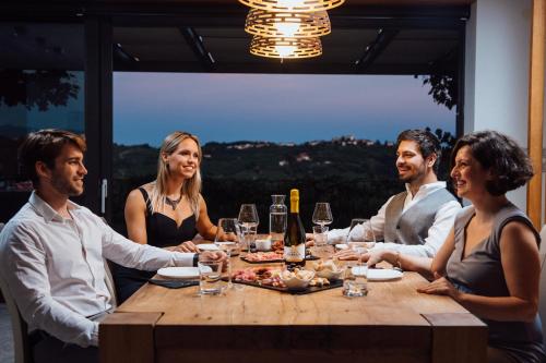a group of people sitting around a table with wine glasses at Villa EVA in Dobrovo