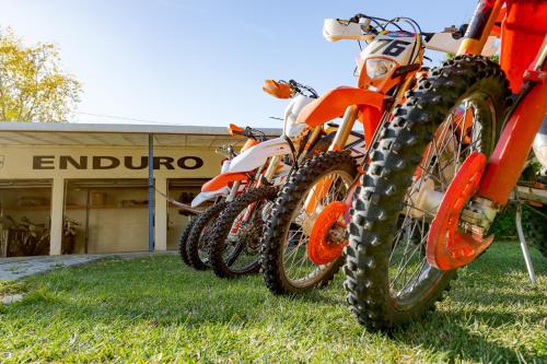 three dirt bikes parked in the grass in front of a store at Casa Augsburg in Băneşti