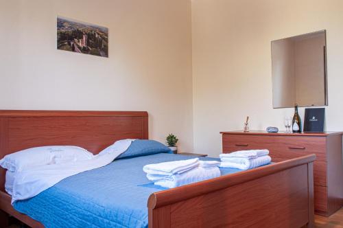 una camera da letto con un letto con lenzuola blu e un comò di Appartamentino a Susegana a Susegana