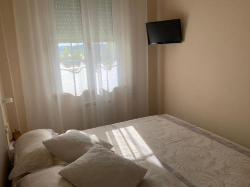 a bedroom with a bed with two pillows and a window at Ca Bea in Alassio