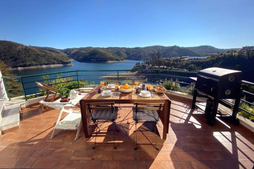 una parrilla y una mesa en el balcón con vistas en Blue Lake House, en Ferreira do Zêzere