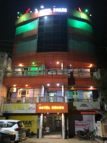 un bâtiment avec des lumières vertes au-dessus dans l'établissement Hotel Swarg, à Muzaffarpur