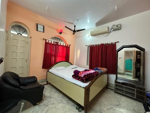 a bedroom with a bed and a mirror and a chair at Hotel Swarg in Muzaffarpur