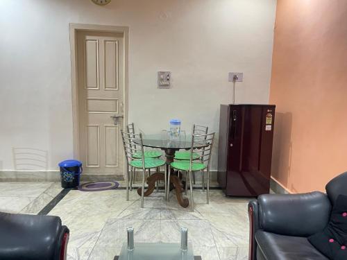 a dining room with a table and chairs and a door at Hotel Swarg in Muzaffarpur