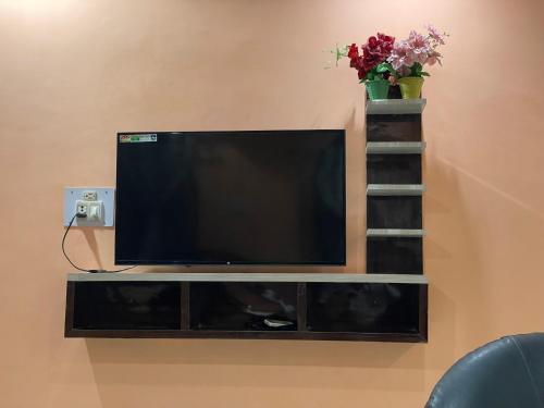Elle comprend une télévision à écran plat installée au-dessus d'un mur. dans l'établissement Hotel Swarg, à Muzaffarpur