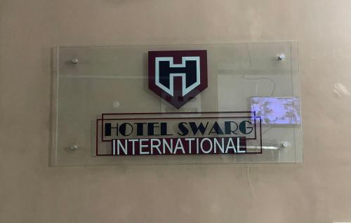 ein Hotel tauscht internationales Schild an einer Wand aus in der Unterkunft Hotel Swarg in Muzaffarpur