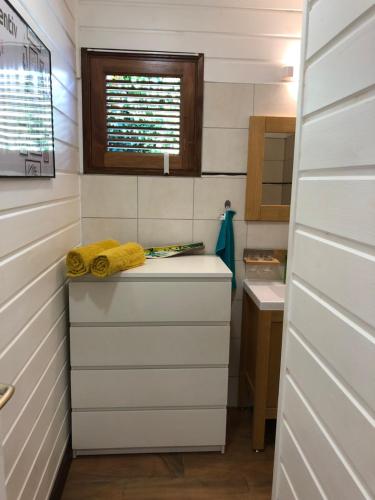 a bathroom with a sink and a yellow towel at Les Frangipaniers de la Pelée in Saint-Pierre