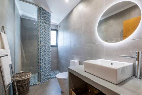 ein Badezimmer mit einem Waschbecken, einem WC und einem Spiegel in der Unterkunft Yuri Big House in Ribeira Brava