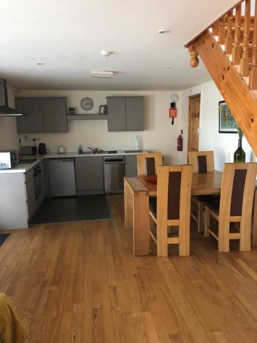 a kitchen and dining room with a table and chairs at The Loft, Ardfert in Ard Fhearta