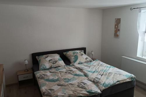 a bed with a comforter and pillows in a bedroom at Ferienwohnung im Fachwerkhaus in Sebnitz