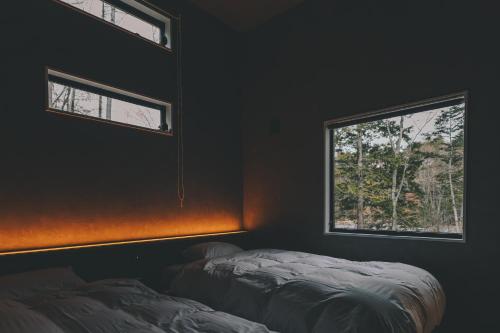 a bedroom with two beds and a window at ASH Villa Fujikawaguchiko in Fujikawaguchiko