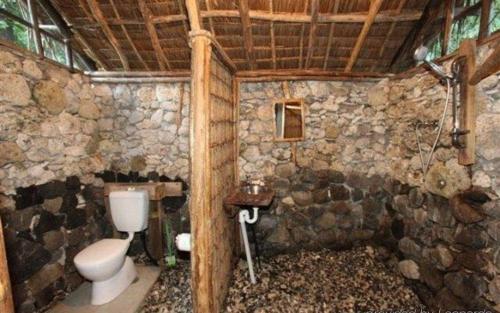 a stone bathroom with a toilet and a sink at Tanna friendly bungalow in Lénakel