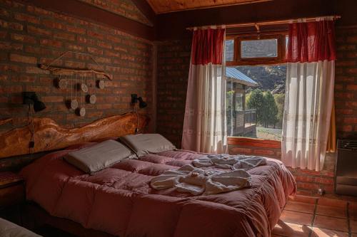 a bedroom with a large bed in front of a window at El Hostal del Rio in Aluminé