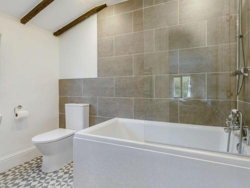 a bathroom with a white tub and a toilet at 2 Bed in Woolacombe 28803 in Bittadon