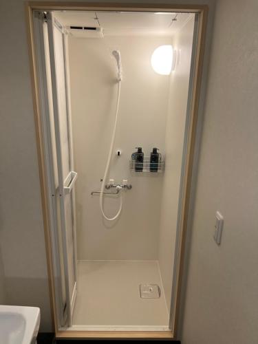 a shower in a bathroom with a sink at 長徳寺宿坊　Temple Hotel in Shingu