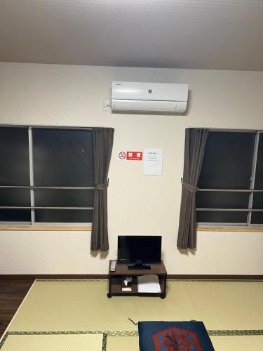 a room with two windows and a laptop on a table at 長徳寺宿坊　Temple Hotel in Shingu