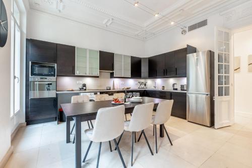 une cuisine avec une table, des chaises et un réfrigérateur dans l'établissement Sweett - Triangle d'Or, à Paris