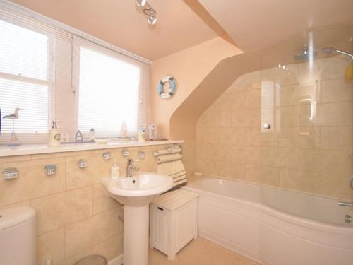 a bathroom with a sink and a tub and a toilet at 1 Bed in St Monans 41693 in Saint Monance