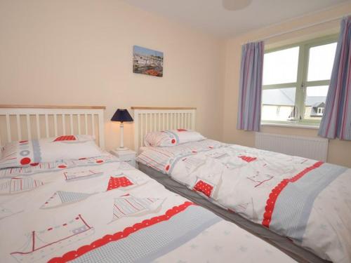 a bedroom with two twin beds with red and white blankets at 3 bed property in Watchet OLDMW in Watchet