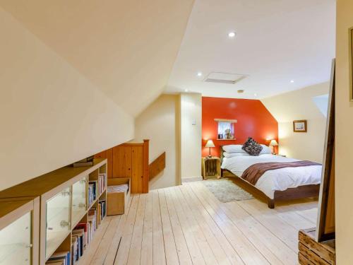 een slaapkamer met een bed met een oranje muur bij 1 Bed in Pershore REDCO in Upton Snodsbury