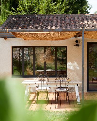 einen Tisch und zwei Stühle auf einer Terrasse in der Unterkunft Petit coin de paradis avec jardin privé et piscine in Saint-Maximin-la-Sainte-Baume