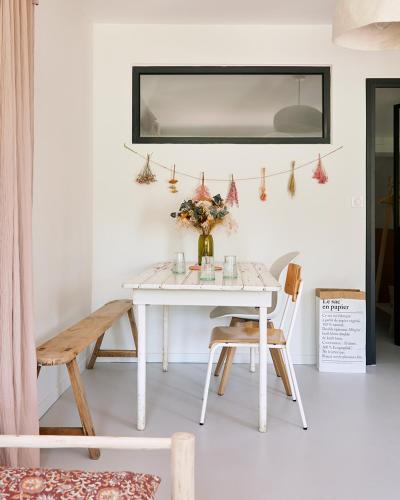 a white dining room table with a vase of flowers at Petit coin de paradis avec jardin privé et piscine in Saint-Maximin-la-Sainte-Baume