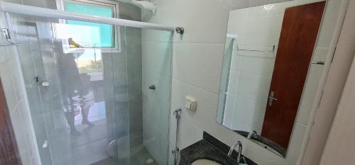 a bathroom with a shower with a glass door at Cobertura Duplex Vista Mar Meaipe in Guarapari