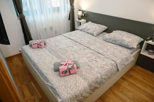 a bed with two pink bows on it at Apartman Knez 2 in Zlatibor