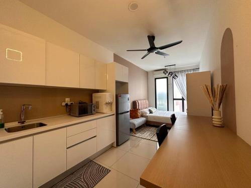 una cucina con ventilatore a soffitto e un soggiorno di Highpark Suites ByTheNook a Petaling Jaya