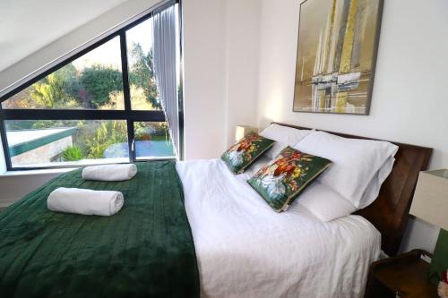 a bedroom with a bed with two pillows and a window at Hutchcomb Villa, 4 Bed Luxury House,Oxford+Parking in Oxford