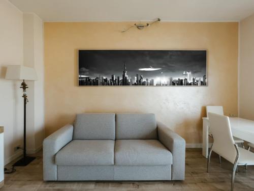 ein Wohnzimmer mit einem Sofa und einem Bild einer Stadt in der Unterkunft Casa Asia in Seriate