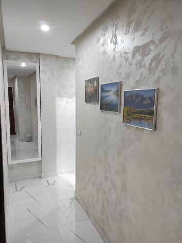 a bathroom with three paintings on a wall at La Joie Al Jadid in Nador