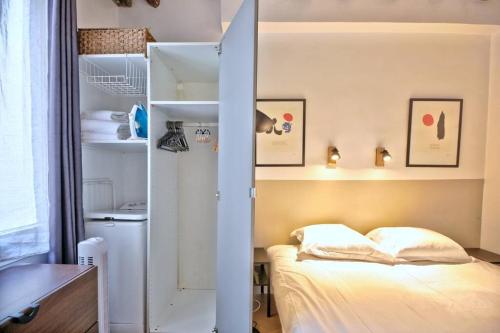 - une petite chambre avec un lit et un placard dans l'établissement 1 bedroom apt only 15 min walk to The Louvre, à Paris