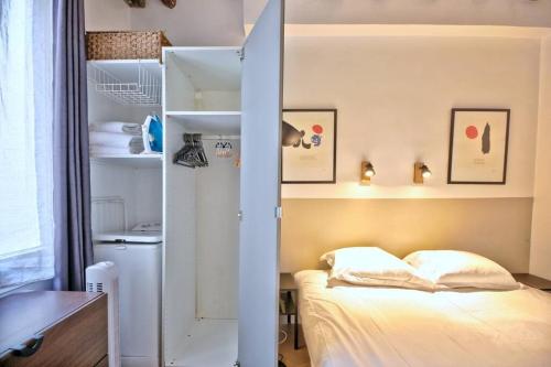 a small bedroom with a bed and a closet at 1 bedroom apt only 15 min walk to The Louvre in Paris