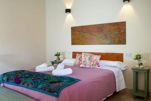 1 dormitorio con 2 camas con almohadas y una pintura en la pared en Amaragua en Fiambala