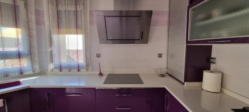 a kitchen with purple cabinets and a sink at Casa Las 7 Maravillas in Fuentidueña de Tajo