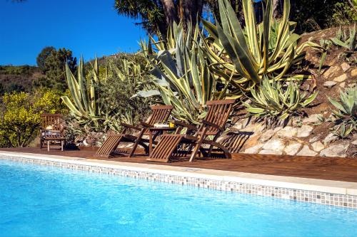 a group of chairs sitting next to a swimming pool at Blue Lake House in Ferreira do Zêzere
