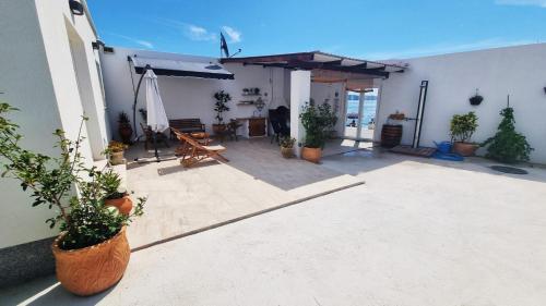 a patio with potted plants on the side of a building at Intimate beachfront house Villa Livak in Kaštela
