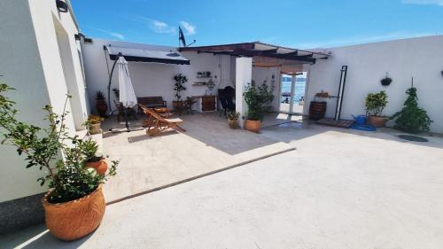 eine Terrasse mit Topfpflanzen an der Seite eines Gebäudes in der Unterkunft Beach house oasis Villa Livak in Kaštela