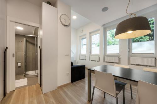 Una cocina y un comedor con una mesa y sillas negras. en Apartma Juniper, en Kranjska Gora