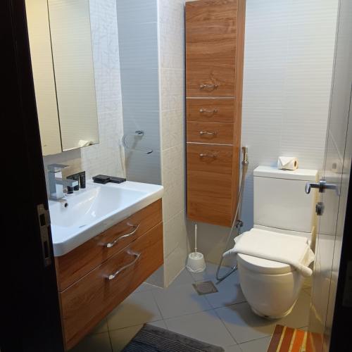 a bathroom with a white toilet and a sink at DUBAI - Glitz 3 Residences - MAJESTIC Luxe Holiday Home - 2BR - Sleep 4 - FOR FAMILIES & COUPLES STAYS ONLY in Dubai