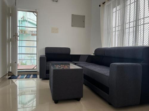 a living room with a blue couch and a table at Segundo Home in Cochin